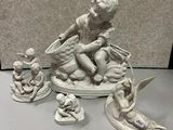 une petite statue représentant un garçon assis sur un bateau, entouré d'anges