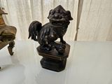 a statue of a dog sitting on a chair next to a statue of a man