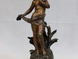 statue en bronze d'une femme tenant un oiseau sur une base en bois