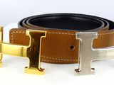 a brown belt with a gold h buckle on it