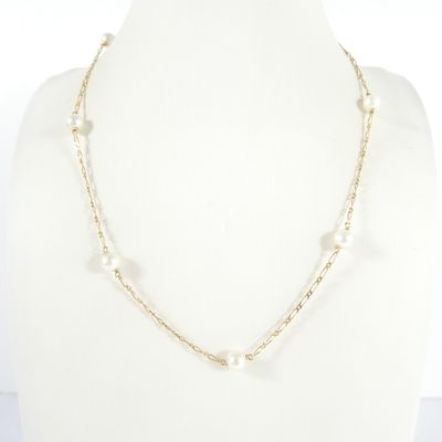 a necklace with pearls and gold chains on a mannequin mannequin