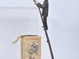 figurine of a man on a ladder with a box and a stick