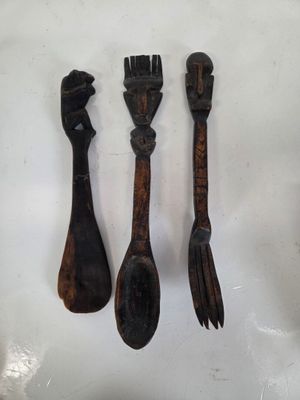 trois cuillères en bois et une fourchette posées sur une surface blanche