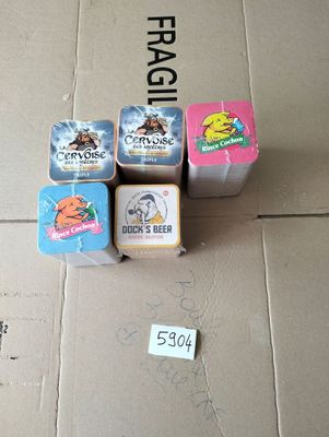quatre canettes de bière posées sur une boîte en carton