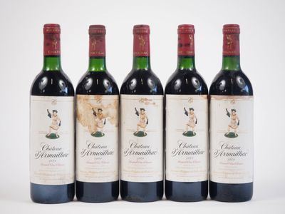 quatre bouteilles de vin rouge sont alignées sur une surface blanche