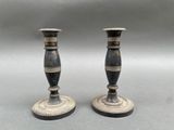 pair of black and silver candlesticks on a grey background