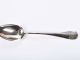 a silver spoon with a silver handle on a white surface