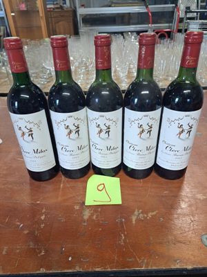 six bouteilles de vin rouge sont alignées sur une table