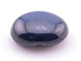 Pierre ovale en onyx noir taillée en cabochon sur fond blanc