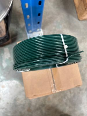 une bobine de fil vert posée sur un carton