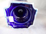 a blue glass vase that has a tag on it
