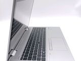a silver laptop with a black keyboard on a white surface