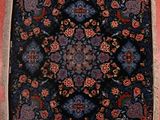 an image of a blue and red rug on a pink wall