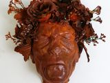 une sculpture représentant une tête ornée de fleurs