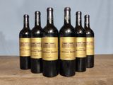 six bottles of wine sitting on top of a wooden table