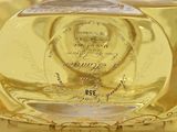 a clear glass bottle with a gold design on it