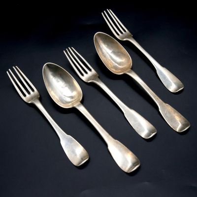 four silver spoons and a fork on a black surface