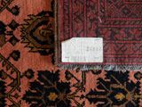 a small piece of paper on a rug with a tag on it