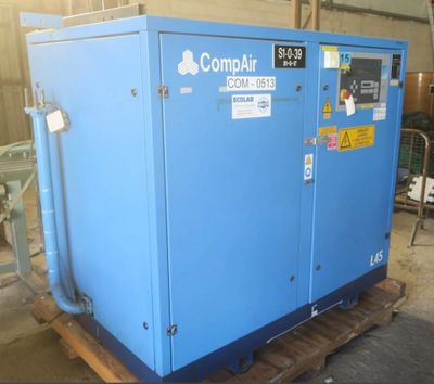an image of a blue compressor sitting on top of a wooden pallet