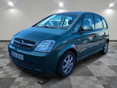une photo d'une petite voiture verte garée dans un garage