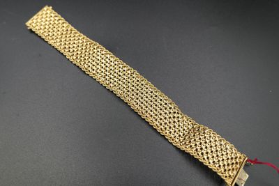 a close up of a gold bracelet on a black surface