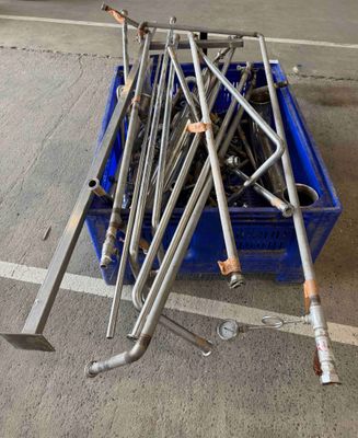 un bac bleu contenant un tas de tiges métalliques