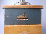 a small blue box with a metal seal on it