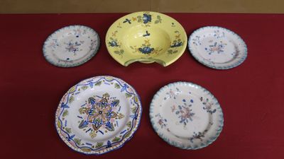 five plates and a bowl sitting on a red table