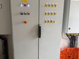 a large electrical panel in a room with orange bins