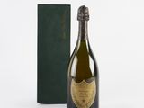 the bottle of champagne is next to a green box on a white surface