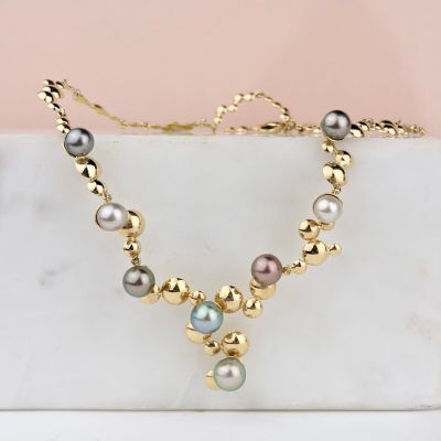 un gros plan d'un collier de perles posé sur une surface en marbre
