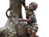 a bronze statue of a woman sitting on a vase