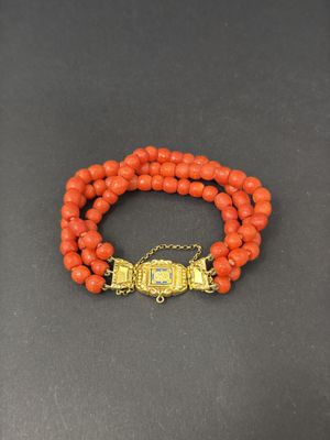 an orange beaded bracelet with a gold clasp