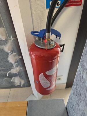 un extincteur fixé à la porte d'un immeuble