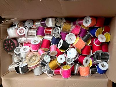 many spools of thread in a box on the floor