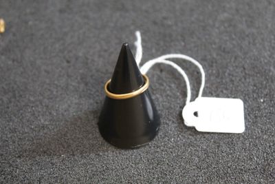 un petit cône noir surmonté d'un anneau doré