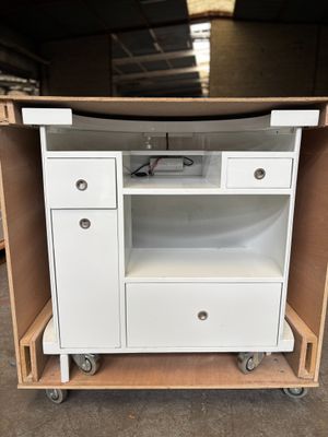 une armoire blanche avec des tiroirs et un micro-ondes sur roulettes