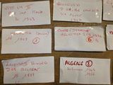 several pieces of white paper with red writing on them on a wooden table