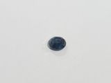 a blue sapphire stone on a white surface