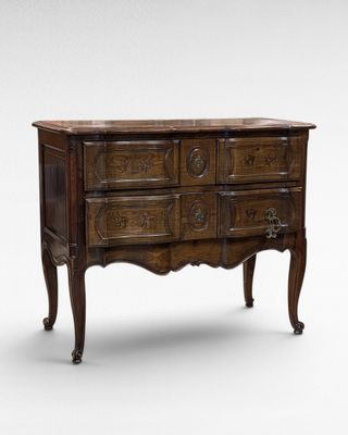 an antique chest of drawers with carved wood and marble top