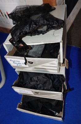 Plusieurs valises ouvertes sont empilées les unes sur les autres sur un tapis bleu