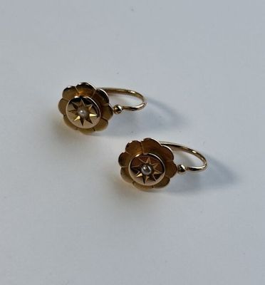 une paire de boucles d'oreilles dorées ornées d'un motif floral