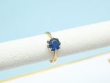 a close up of a ring with a blue stone on it