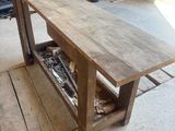 une table en bois sur laquelle est posé un vélo, dans un garage