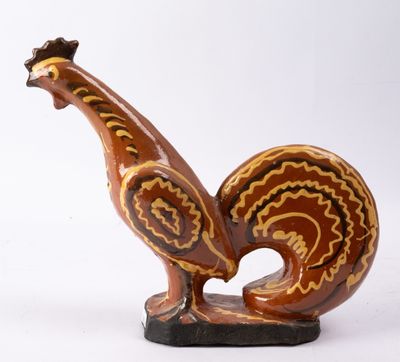 une figurine représentant un coq sur fond blanc