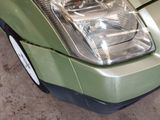 a close up of a car ' s headlight on a green vehicle