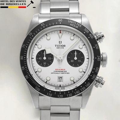 a close up of a watch with a white face and black bezel