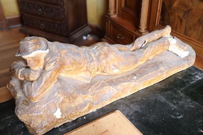 une statue représentant un homme allongé sur une table