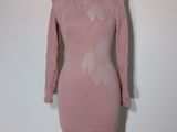 pink dress on a mannequin stand against a white wall