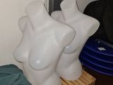 trois mannequins blancs posés sur une étagère en bois